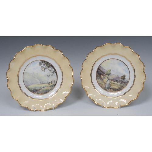 122 - A pair Royal Crown Derby shaped circular plate, painted by Stefan Nowacki, with Buttertubs Pass, Yor... 