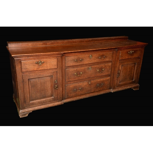 1574 - A George III oak low dresser, moulded top above an inverted break-centre arrangement of five drawers... 