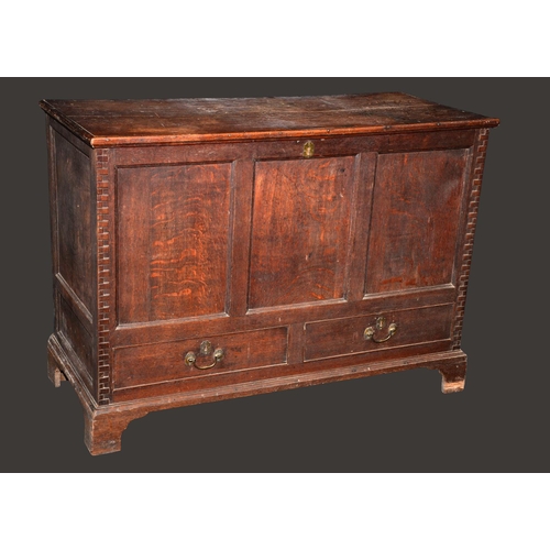 1576 - A George III oak mule chest, hinged top, three panel front flanked by architectural rusticated angle... 