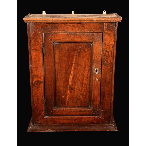 1579 - A George III oak wall cupboard, outswept cornice above a panelled door enclosing shelves, 79.5cm hig... 