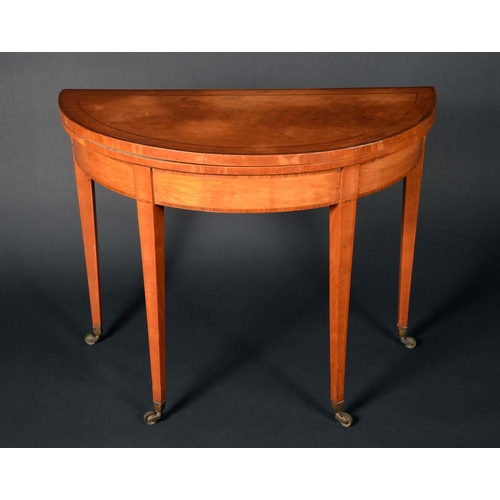 1584 - A George III rosewood crossbanded satinwood demi-lune card table, folding top above a deep frieze, t... 