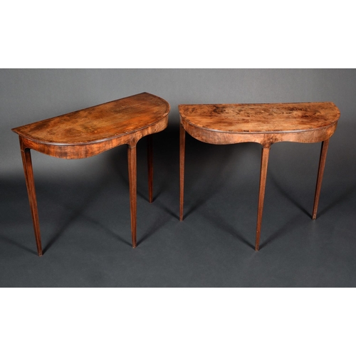 1585 - A pair of George III mahogany D-shaped side tables, crossbanded tops above shaped friezes, tapered s... 