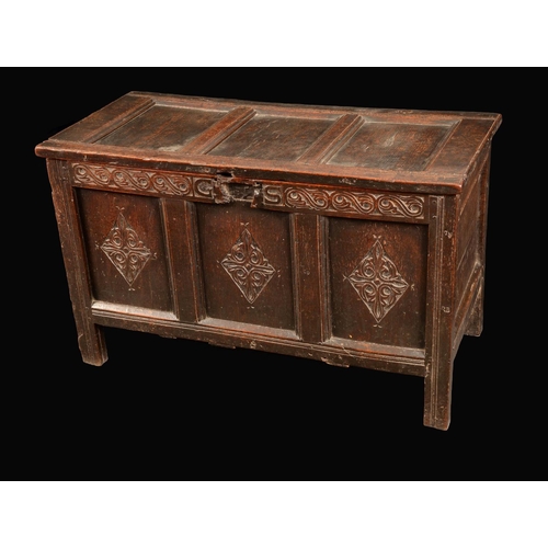 1600 - A late 17th century oak three panel blanket chest, hinged top, the front carved with a frieze of lea... 