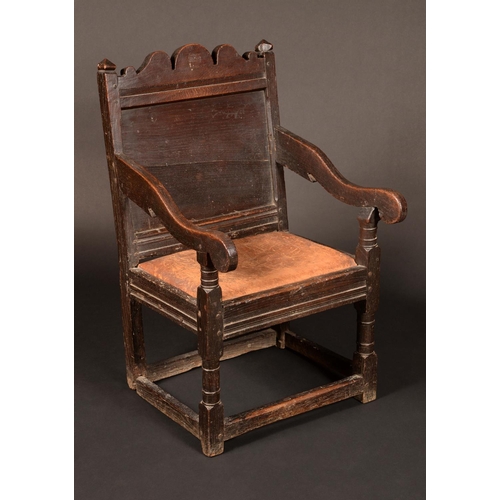 1602 - A late '17th' century Wainscote chair, shaped cresting flanked by pyramid finials, scroll arms, turn... 