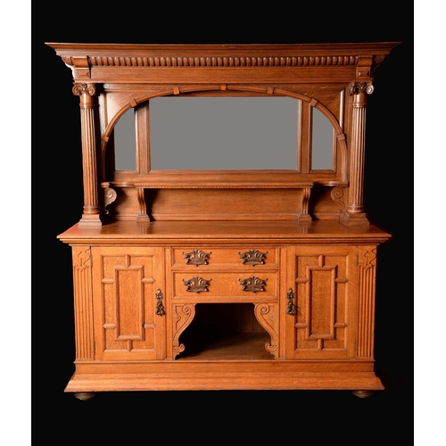 1604 - A late Victorian oak sideboard, fluted outswept cornice above an arched niche with mirror and shelf,... 