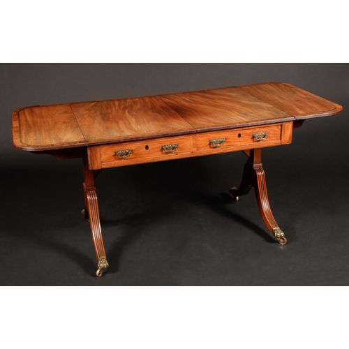 1626 - A Regency mahogany rounded rectangular sofa table, crossbanded reeded top above a pair of frieze dra... 