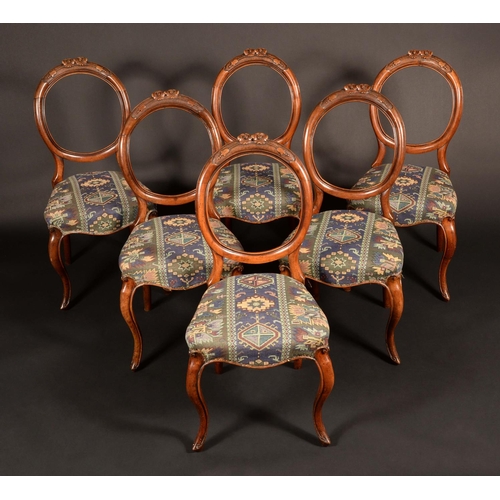 1635 - A set of six Victorian walnut cartouche back dining chairs, carved crestings, stuffed-over seats, ca... 