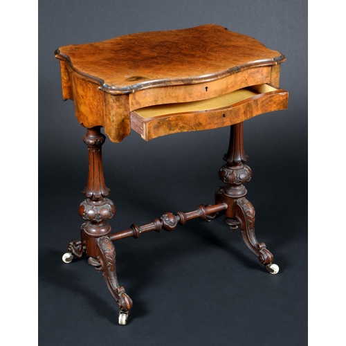 1660 - A Victorian walnut serpentine work table, hinged top enclosing a mirror and an arrangement of compar... 