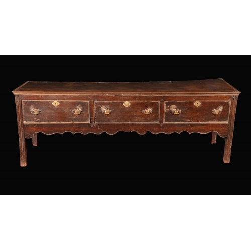 1684 - An early George III oak low dresser, rectangular top above three deep cockbeaded drawers, brass swan... 