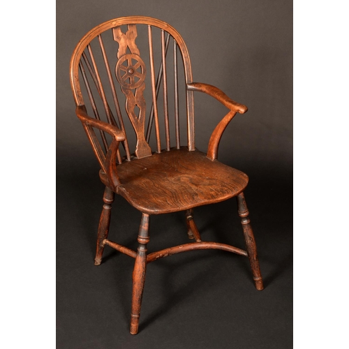 1711 - A 19th century elm wheelback Windsor elbow chair, serpentine arms terminating with scrolls, saddle s... 