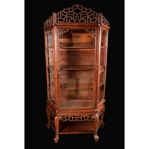 1723 - A Chinese padouk canted rectangular display cabinet, shaped and pierced pediment above a rectangular... 