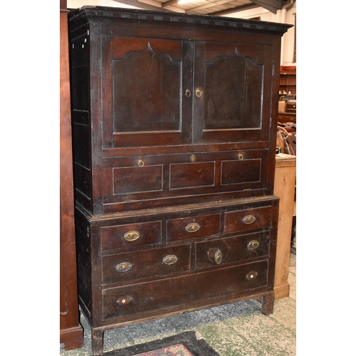 1732 - A 18th century oak housekeepers cupboard, outswept cornice  above a pair of ogee panelled doors and ... 