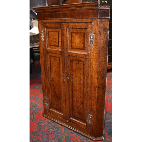 1743 - A George III oak and mahogany crossbanded splay-fronted wall hanging corner cupboard, moulded skirte... 