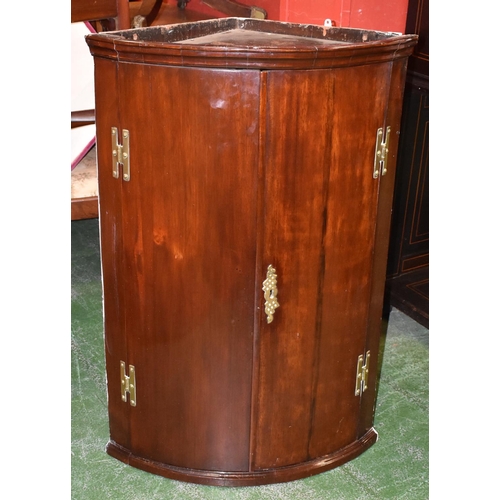 1744 - A George III mahogany bow-fronted wall hanging corner cupboard, moulded top above a pair of concave ... 