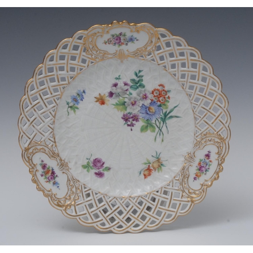 235 - A Meissen shaped circular basket-weave plate, painted with colourful summer flower, pierced border w... 