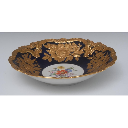 236 - A Meissen shaped circular dish, the centre painted with colourful spring flowers with rim in relief ... 