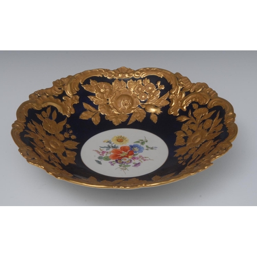 236 - A Meissen shaped circular dish, the centre painted with colourful spring flowers with rim in relief ... 