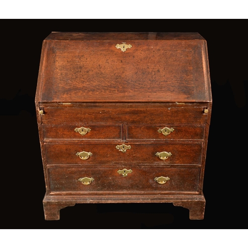 1416 - A George II oak bureau, fall front enclosing an arrangement of pigeon holes and small drawers centre... 