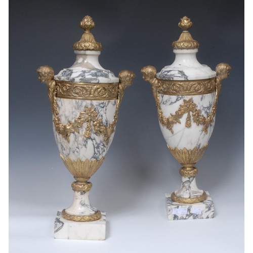 1422 - A pair of Louis XVI Revival gilt-metal mounted Breccia marble manel urns, applied with trailing bell... 