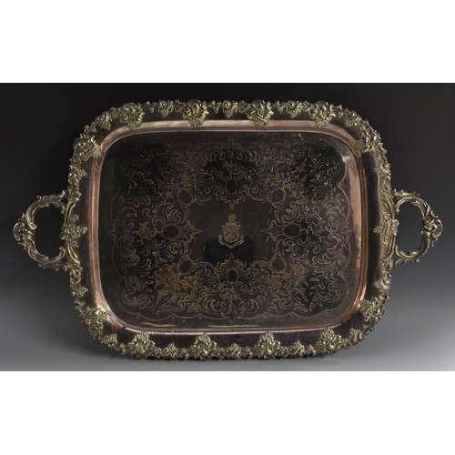 4 - A large Victorian two-handled serving tray, the field engraved and chased with crest and scrolling f... 