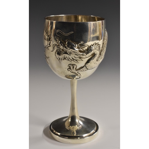 45 - A Chinese silver pedestal goblet, the hemi-ovoid bowl chased with a dragon in pursuit of a flaming p... 