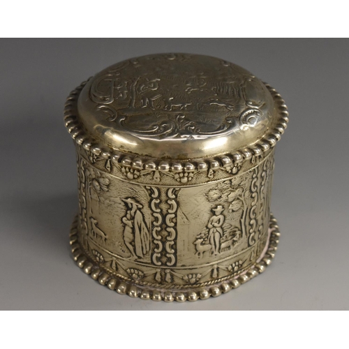 59 - A Dutch silver circular box and cover, chased with figures in 18th century dress, domed push-fitting... 