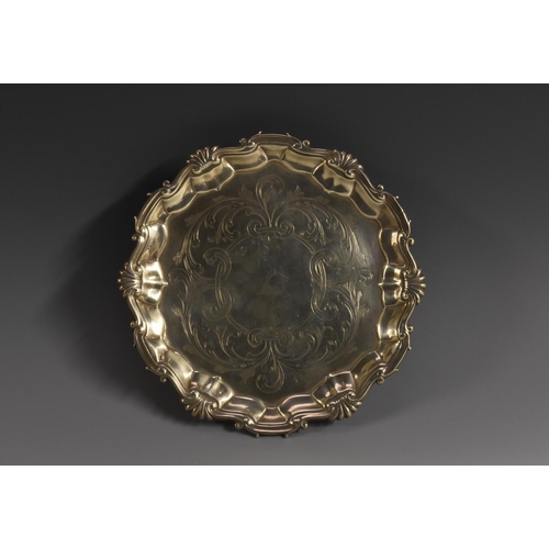 66 - A George II shaped circular tray, he field engraved with crest within scrolling acanthus leaves, she... 