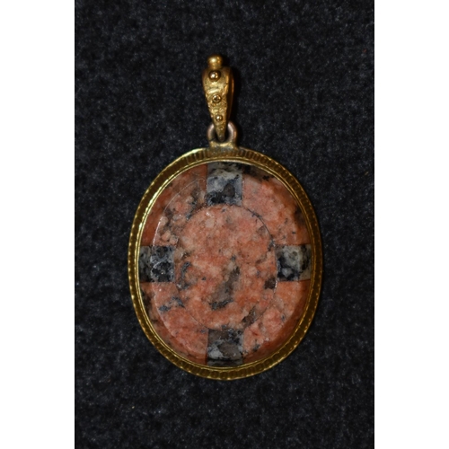 3163 - A chalcedony and yellow metal oval pendant,central multi tone oval panel within conforming cross qua... 