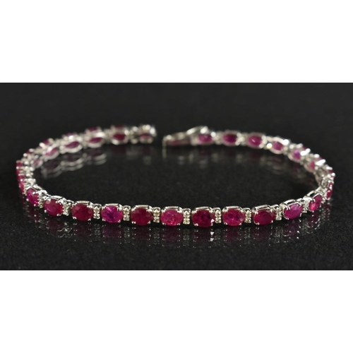 3167 - A diamond and ruby tennis bracelet, alternate set with twenty seven oval mixed cut pinky red rubies,... 