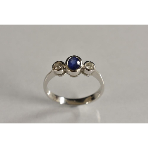 3173 - A sapphire and diamond trilogy ring, central oval blue sapphire approx 0.30ct, flannked by a singel ... 