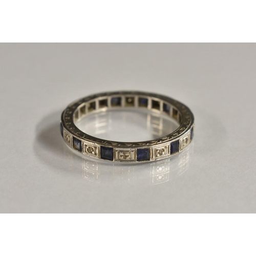 3205 - A diamond and sapphire full eternity ring, alternate set with twelve square cut blue sapphires and t... 