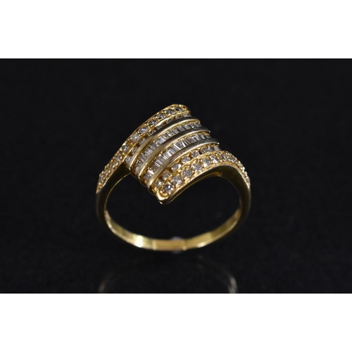 3211 - A diamond cluster ring, arching diamond shaped platform encrusted with twenty six trapezoid/baguette... 