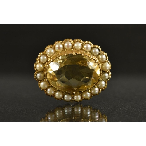 3220 - A 9ct gold oval pale yellow stone and seed pearl brooch, set with a central faceted oval stone, surr... 