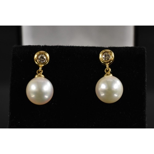 3225 - A pair of 18ct gold diamond and cultured pearl drop earrings, diamond tipped stud fitting, each appr... 