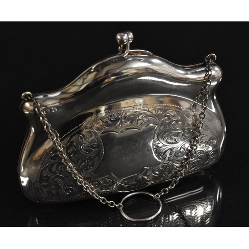 3379 - A silver evening purse, chased scrolling foliate decoration, vacant cartouche, chain and finger ring... 