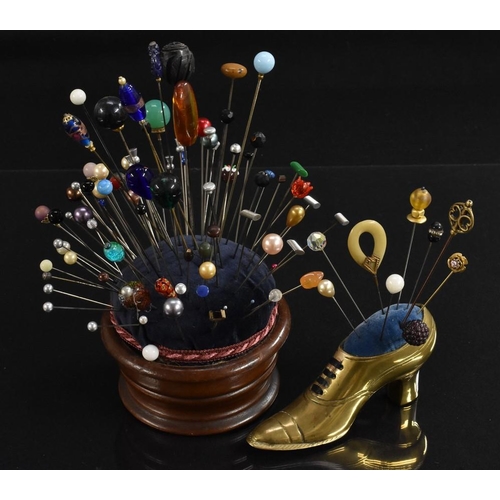 3394 - A turned mahogany pin cushion; a brass pin cushion as a lady's shoe; a quantity of hat pins