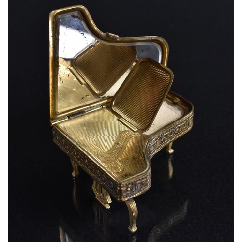 3399 - A gilt brass novelty musical powder compact, as a grand piano, The Pygmalion