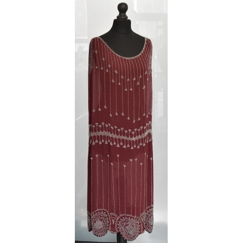 3414 - A 1920s claret silk flapper style dress, scalloped hemline, heavily beaded with pearlescent spherica... 