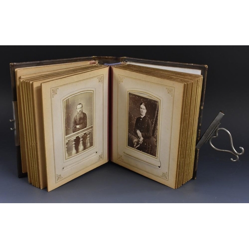 3482 - A photograph album, leather bound, gilt tooling, clasp fastening dated 1881, containing family portr... 