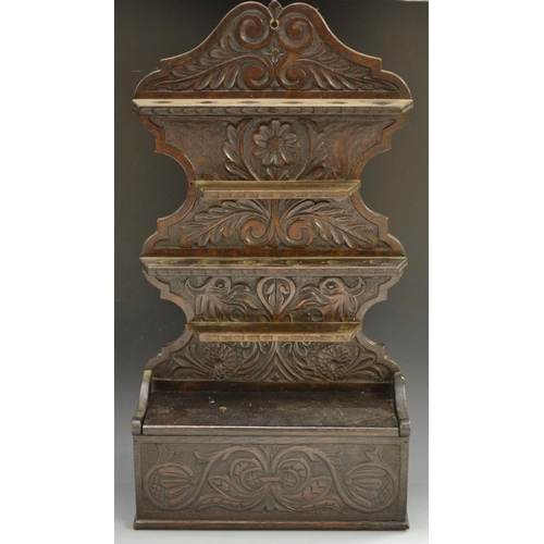 5052 - A 19th century oak spoon rack, shaped back carved withflowerheads and stiff acanthus, candle box to ... 