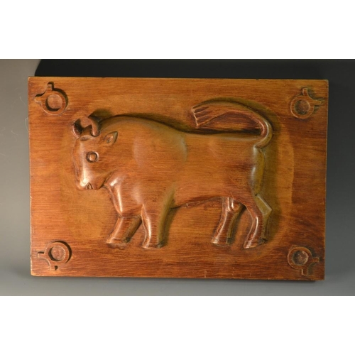 5085 - A folk art panel, naively carved in relief with a bull, 35cm wide