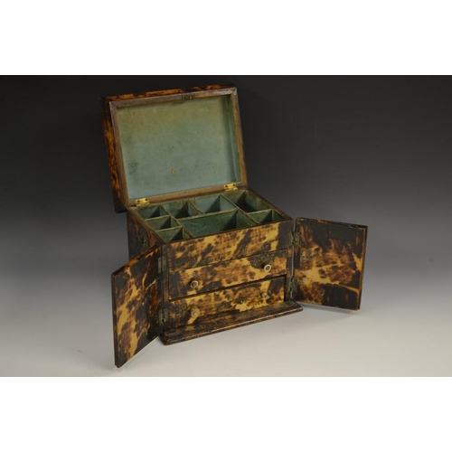 5091 - A George III faux tortoiseshell scumbled table cabinet, hinged top enclosing an arrangement of compa... 