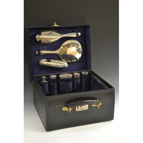 5099 - A George V gentleman's black leather travelling case, comprising hair brush, hand mirror and clothes... 