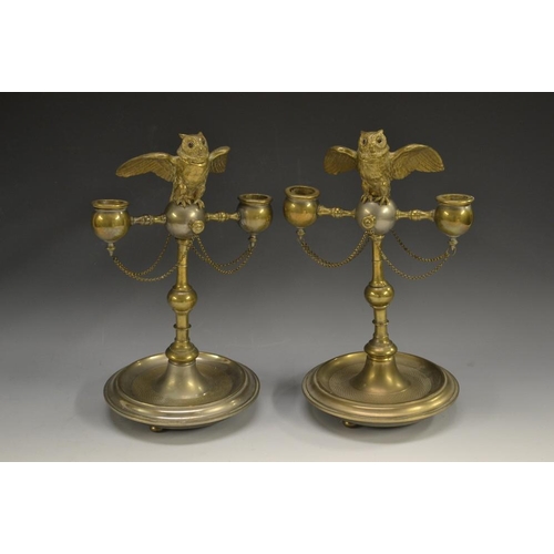 5146 - A pair of 19th century silvered and gilt novelty candelabra, each crested by an owl  perched on a ba... 