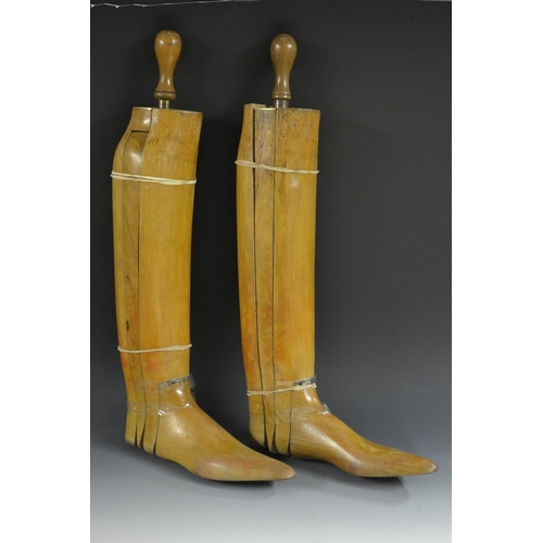 5152 - A pair of early 20th century beech gentleman's riding boot trees, brass mounted wedges with turned h... 