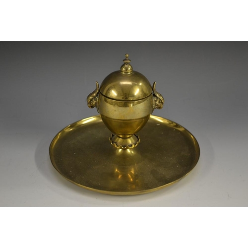 5186 - A Victorian brass desk inkwell, hinged cover with knop finial, parakeet masks to sides, crenellated ... 