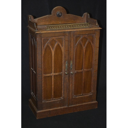 5195 - A Victorian Gothic Revival oak table cabinet, shaped three quarter gallery centred by a draught turn... 