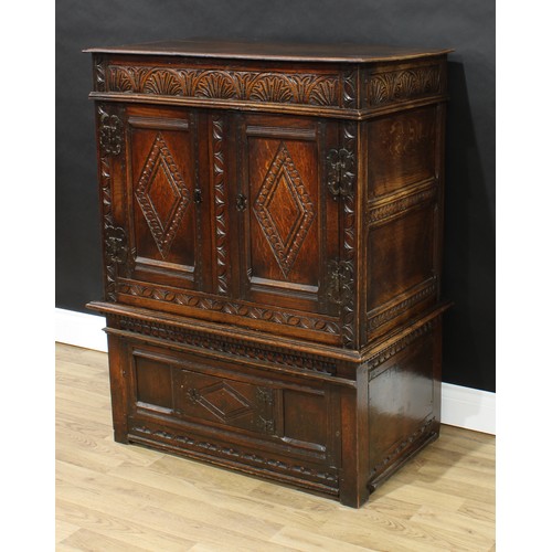 79 - An '18th century' oak cabinet on stand, rectangular top above a deep frieze and a pair of doors, car... 