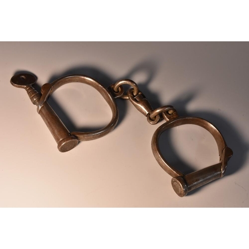 3376 - Policing Interest - a pair of 19th century Froggatt-type iron handcuffs, of typical form, key en sui... 