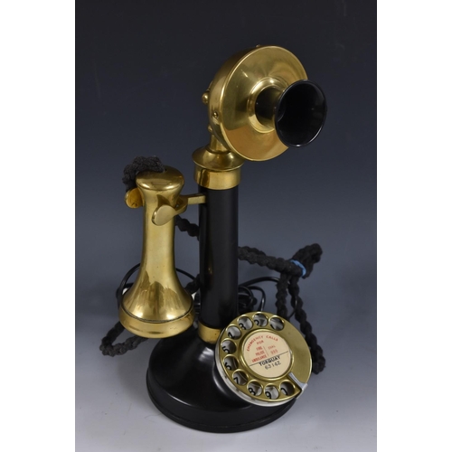 3969 - An early 20th century black lacquered and brass candlestick telephone, inscribed Torquay telephone n... 